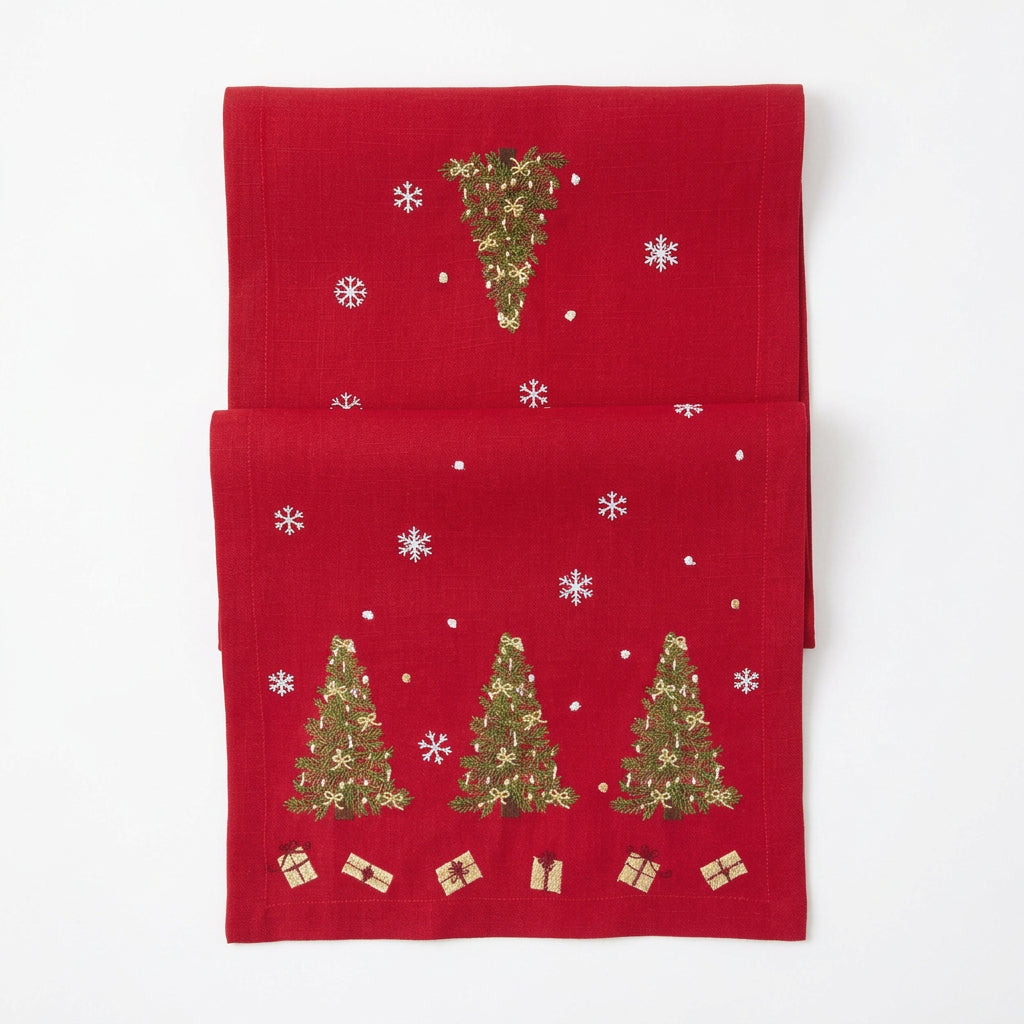 A red Christmas table runner featuring three Christmas trees with small gold gift boxes and white sequin snowflakes on a plain white background.