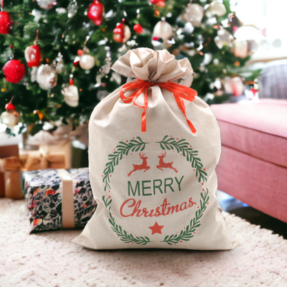 A rustic burlap sack with a 'Merry Christmas' message and decorated with a red bow, placed under a decorated Christmas tree.