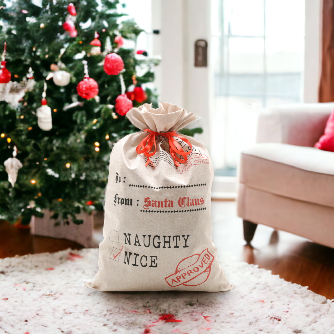 A beige Santa sack with 'Naughty or Nice' text and a red bow, placed near a Christmas tree.