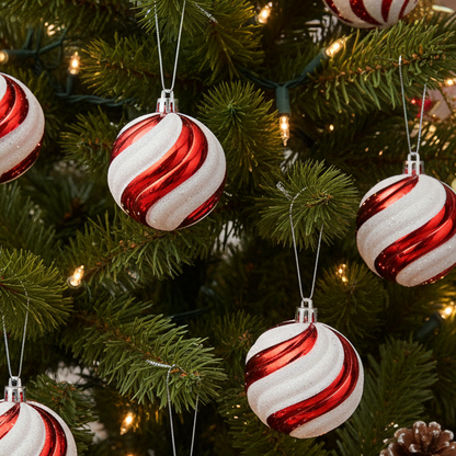 Red and white striped ornaments on a Christmas tree with lights.