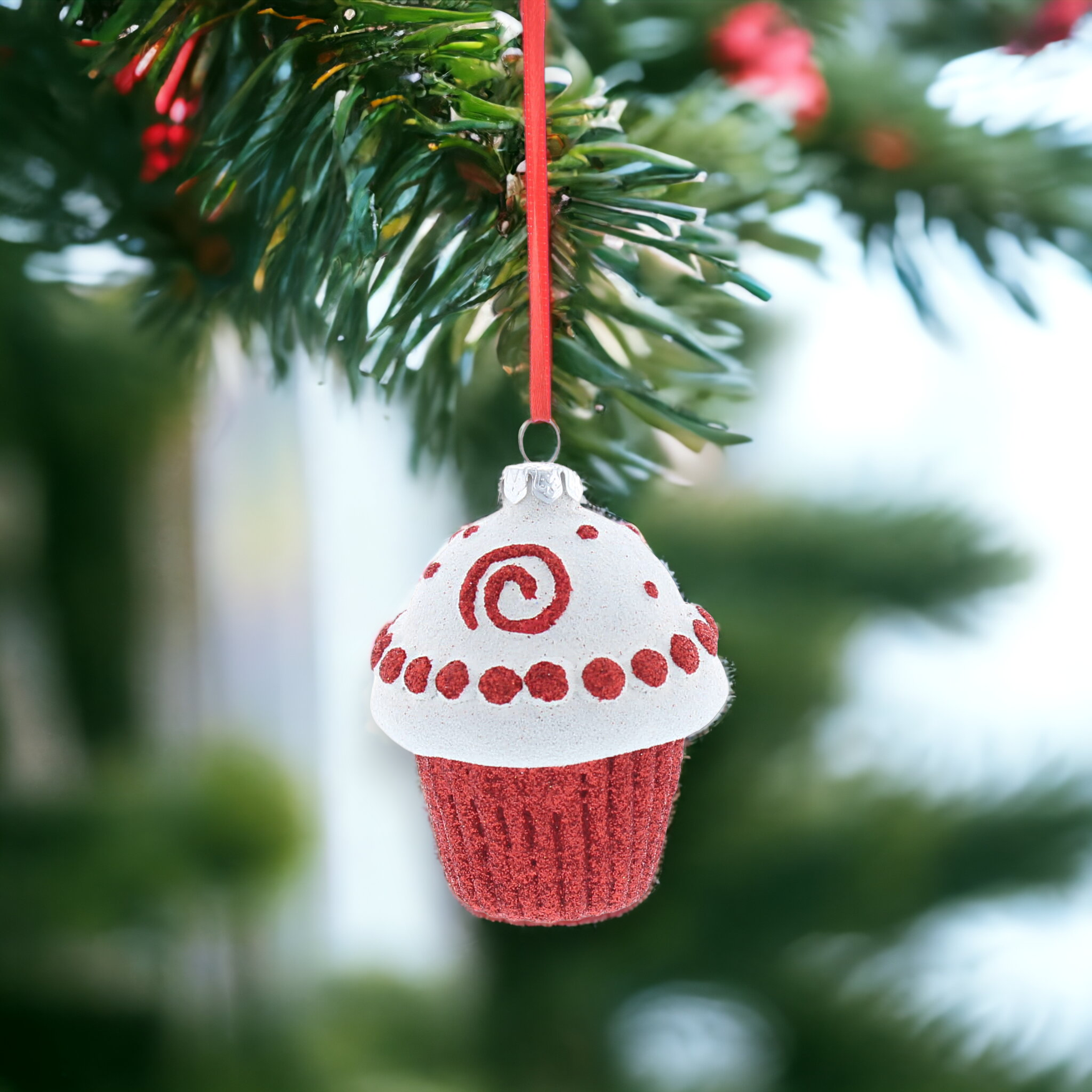A red and white glittery cupcake-shaped hanging decoration with a red hanging string.