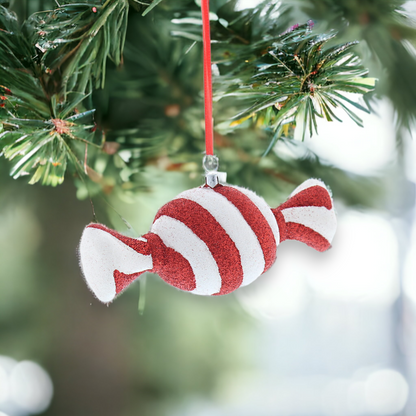 A red and white glittery striped hanging decoration resembling a sweet, with a red hanging string.