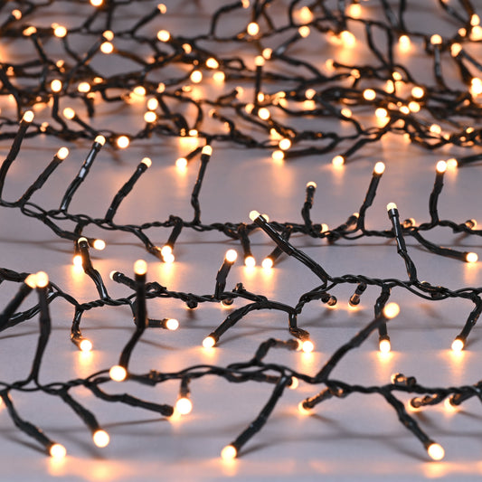 A string of warm white glow worm cluster lights on a white background.
