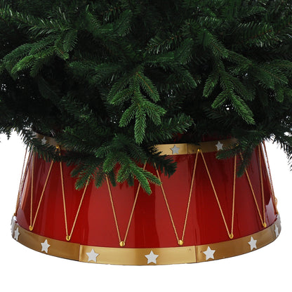 A red drum-shaped artificial Christmas tree skirt with gold trim and white stars, holding a green artificial tree against a white background.