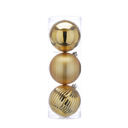 Three gold Christmas ornaments stacked inside a clear plastic box on a white background