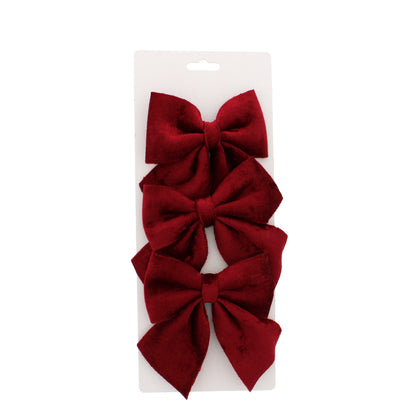 Three burgundy bows on a white card against a white background