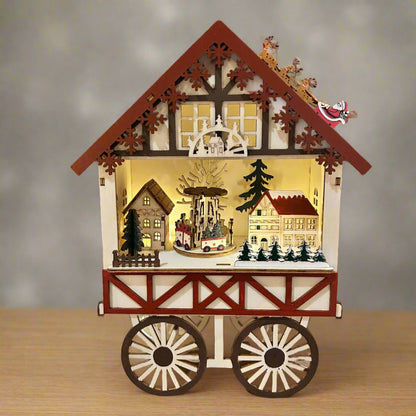 A wooden Christmas cart with a market scene inside, featuring a traditional German style with decorations such as a Christmas tree and village-inspired design.