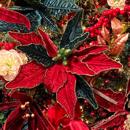 A close-up of a red and green poinsettia stem with artificial leaves, designed for use in holiday decorations.