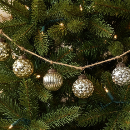 Decorative Christmas tree with silver and gold ornaments and lights.