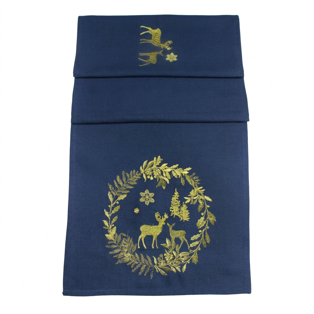 A navy blue table runner with gold embroidered holiday motifs, including a wreath with deer and snowflakes, shown against a white background.