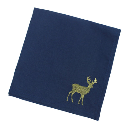 A navy blue square fabric napkin featuring an embroidered golden stag motif in the lower right corner, displayed on a clean white background.
