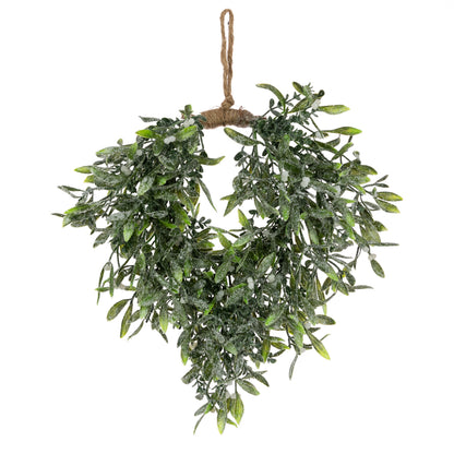 An artificial green leafy wreath with a rustic brown jute hanging loop and twine base, decorated with white snow-like dusting, shown against a plain white background.