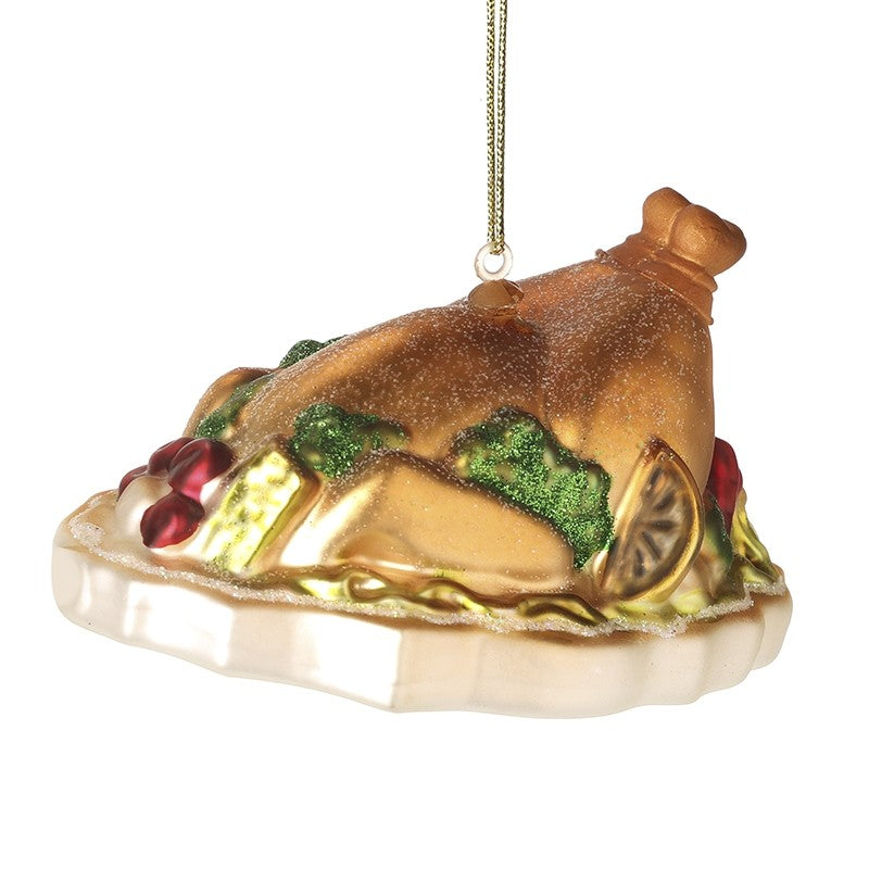Decorative Christmas ornament shaped like a roasted turkey with vegetables on a white background