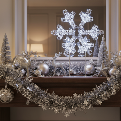 Decorative Christmas mantel with a large snowflake light, tinsel, and ornaments.