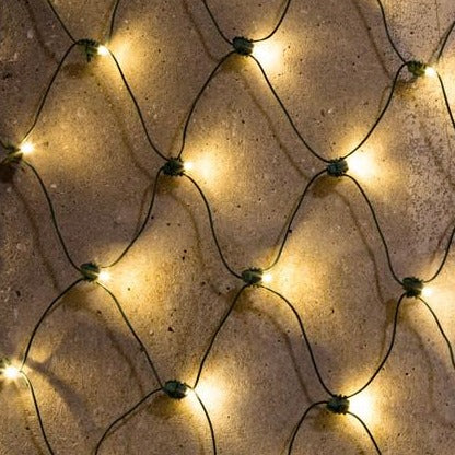 A close-up view of warm white LED net lights illuminated against a textured background.