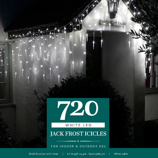 A house at night decorated with white LED jack frost icicle lights hanging from the gutters, with the brand name '720 White LED Jack Frost Icicles' displayed.