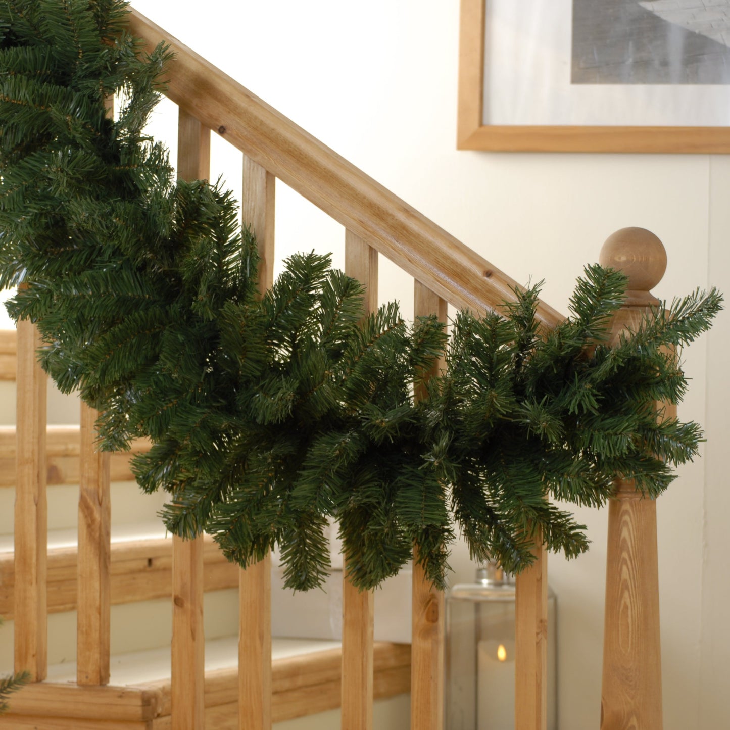 A green Christmas garland decoration draped over a staircase banister.