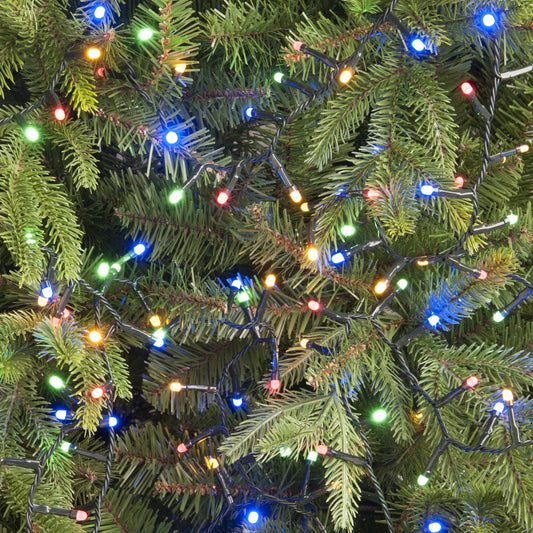 A close-up of a Christmas tree decorated with multi-colored glow worm lights.