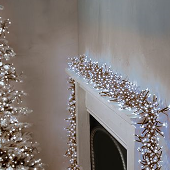 Cluster of white LED Christmas lights strung along a fireplace, creating a festive and bright display.