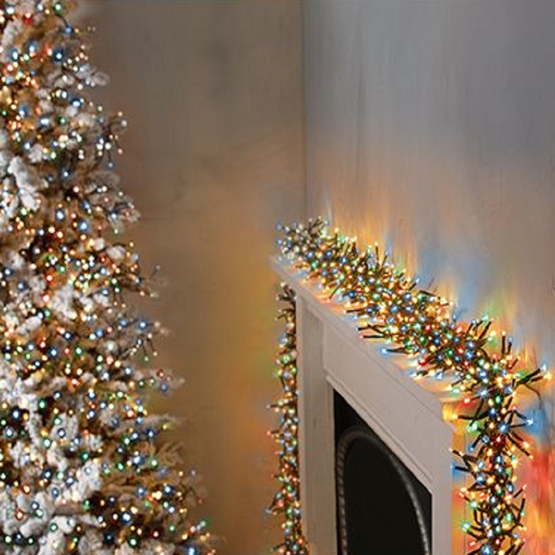 Colorful Christmas tree lights on a decorated tree, with a focus on the multi-colored strand of lights hanging over a white fireplace.
