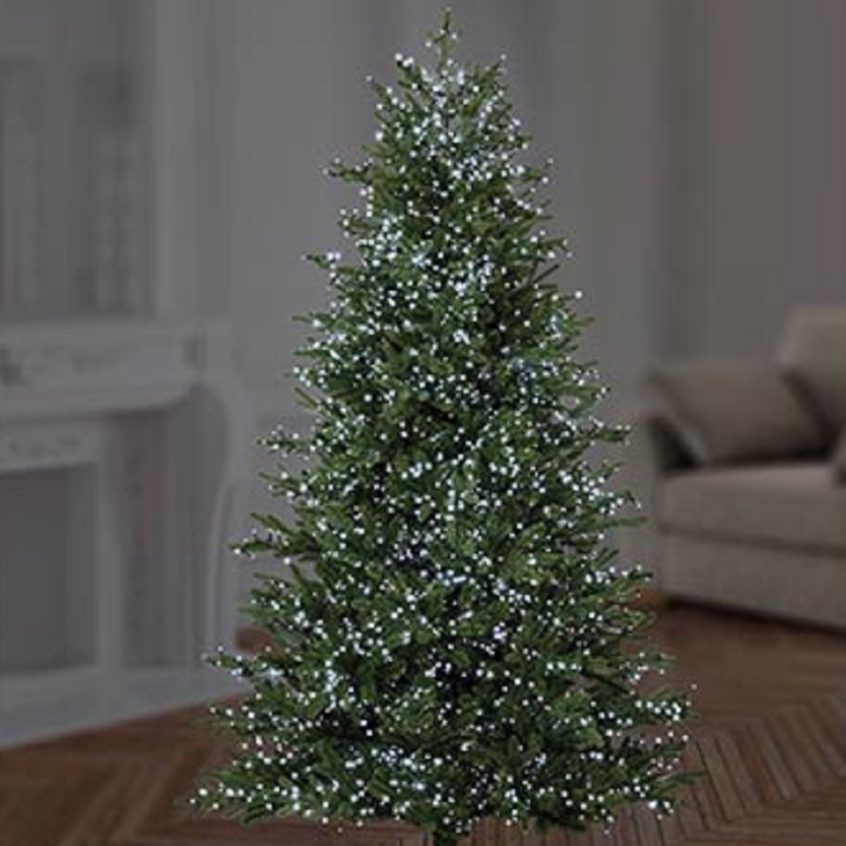 A artificial Christmas tree with white LED lights, placed on a floor in a home environment.